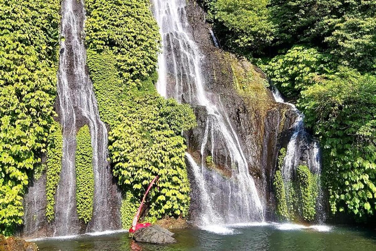 una cascata con una barca nell'acqua di fronte