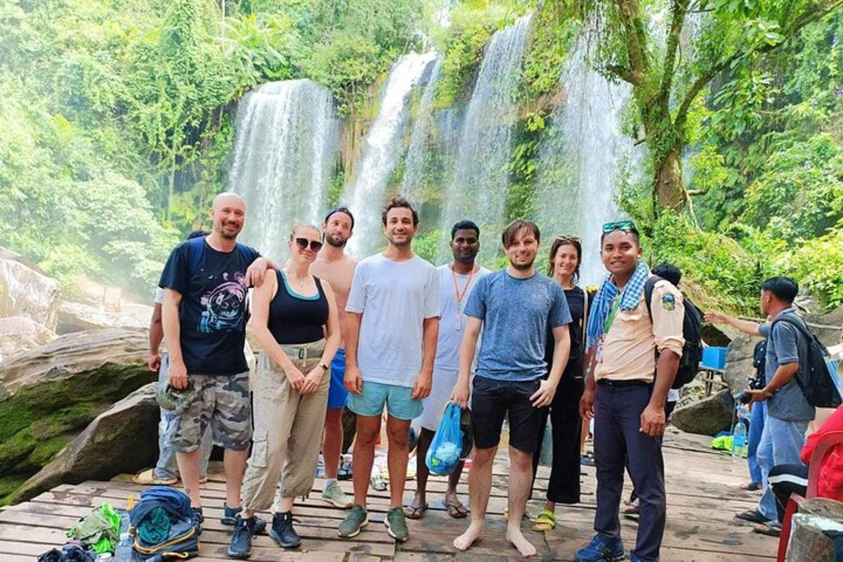 a group of people standing in front of a waterfall