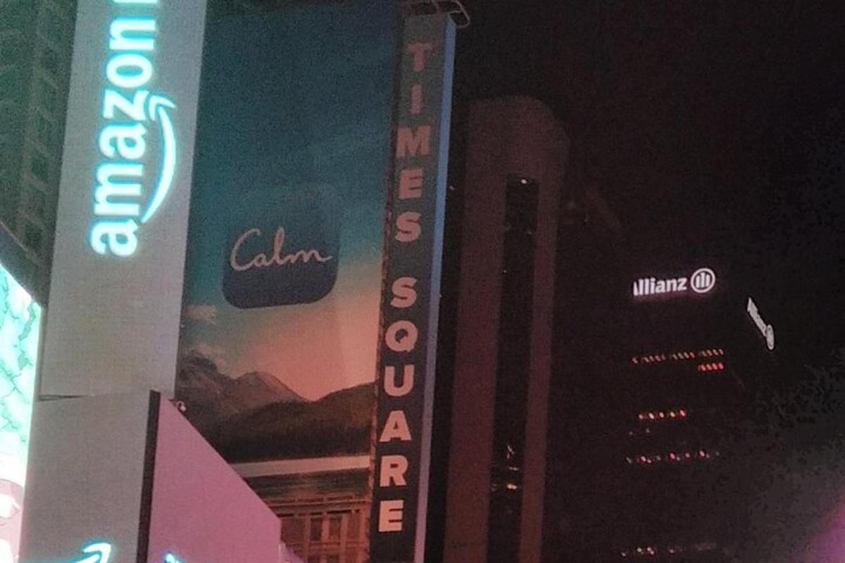 a tall building with a sign on it in a city