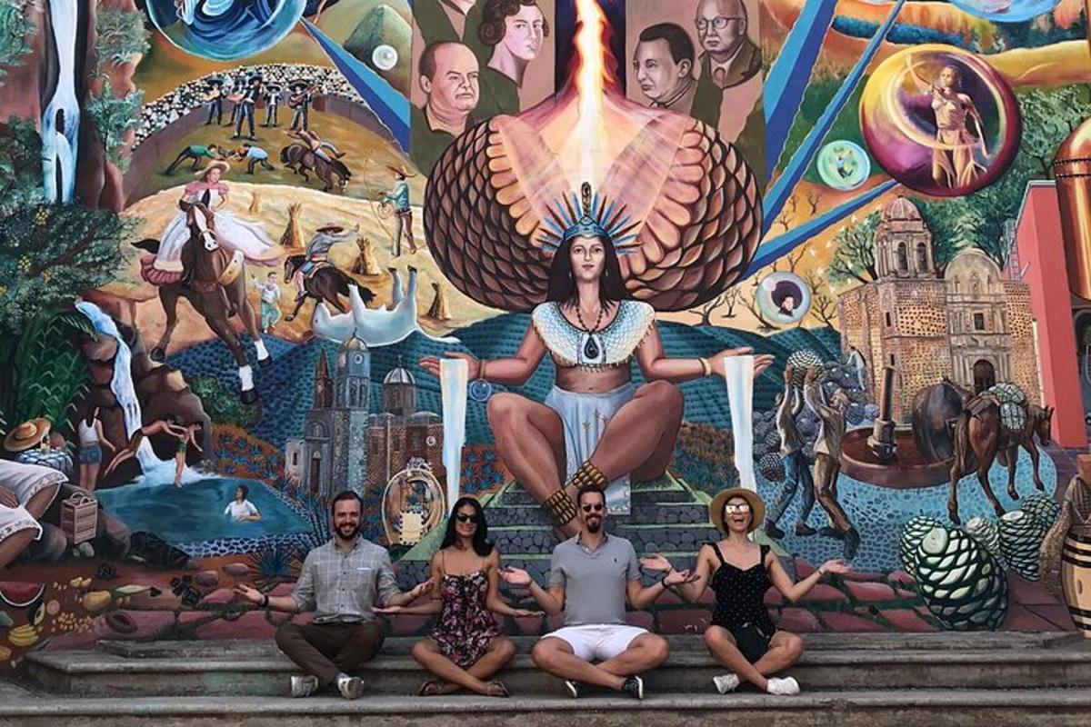 sekumpulan orang duduk di hadapan mural