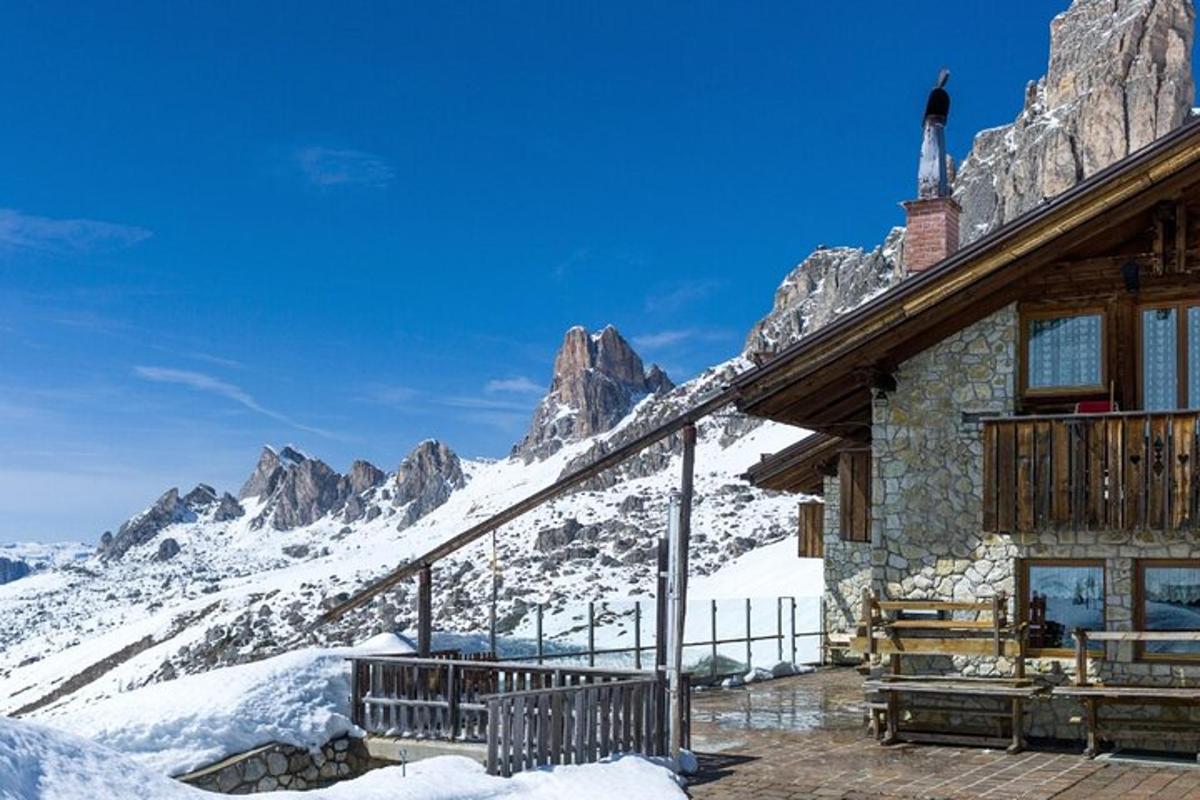 pondok ski dengan latar belakang gunung yang dilitupi salji