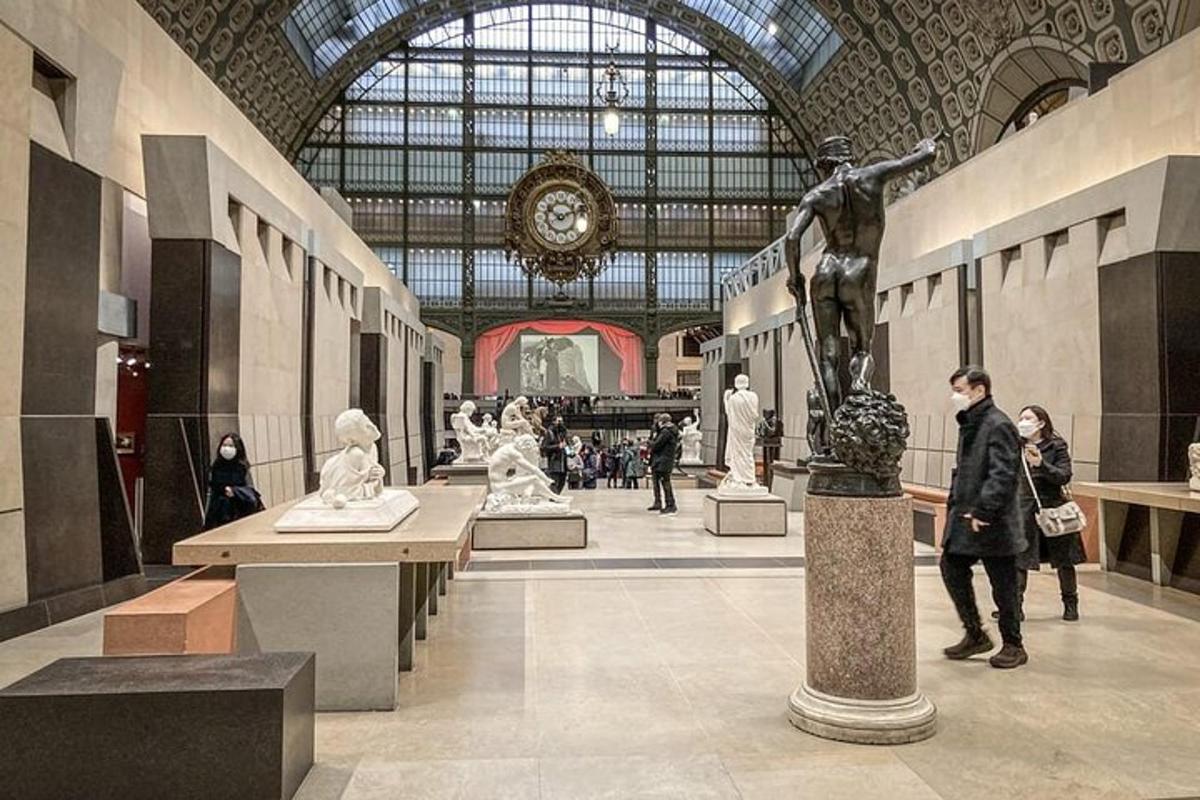 a group of people walking around a museum with statues