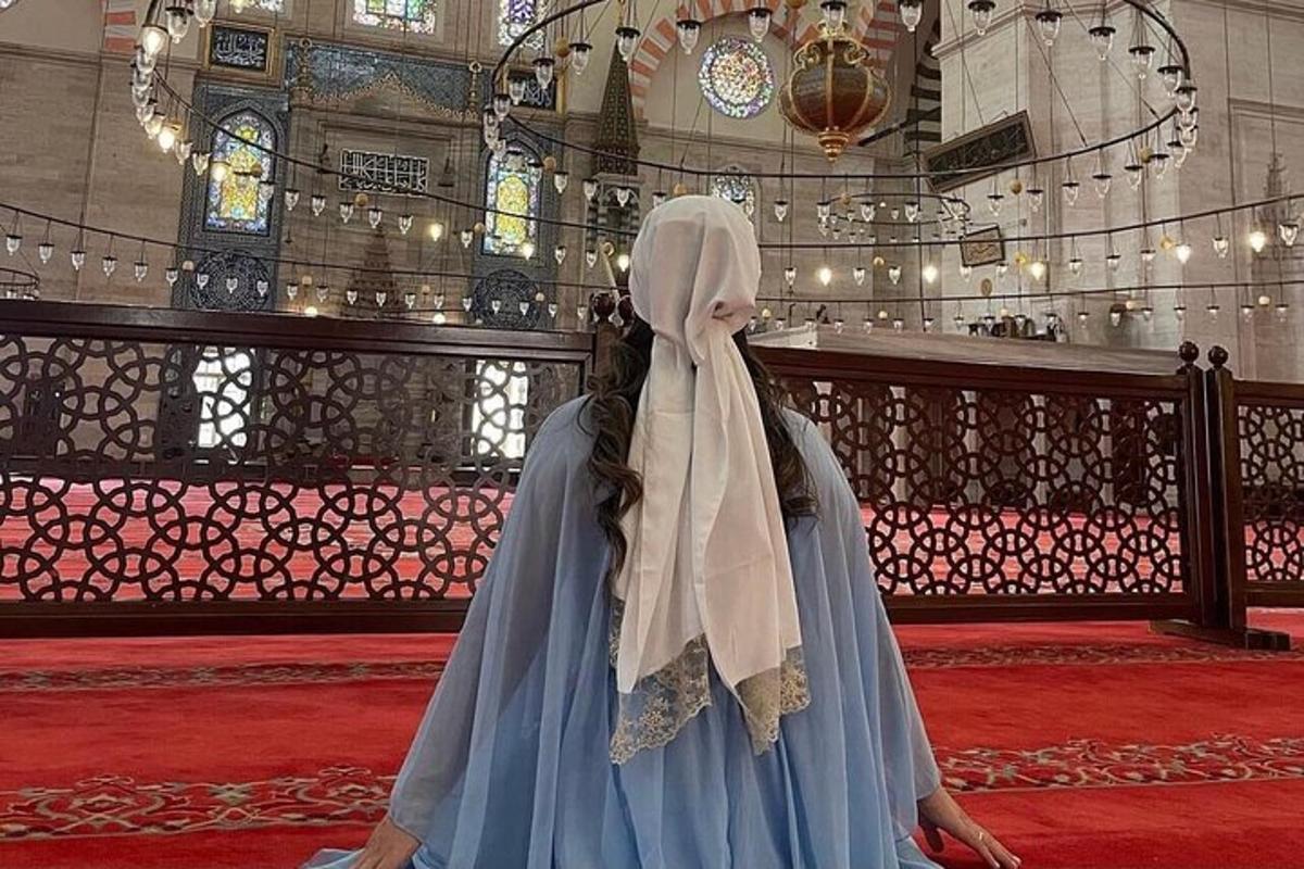 Una mujer con un vestido azul parada en una iglesia.
