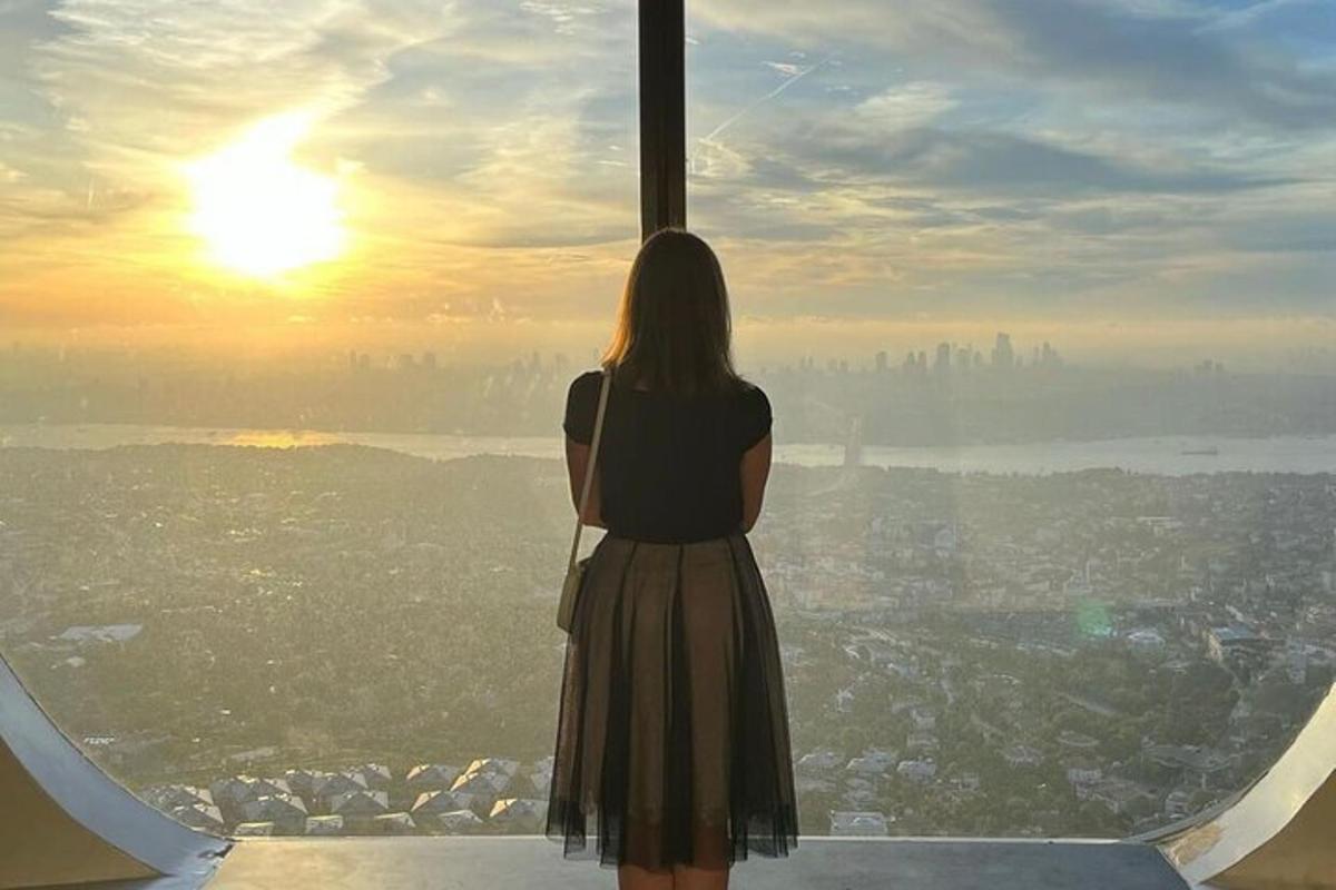 Una mujer parada en lo alto de una torre mirando la ciudad.