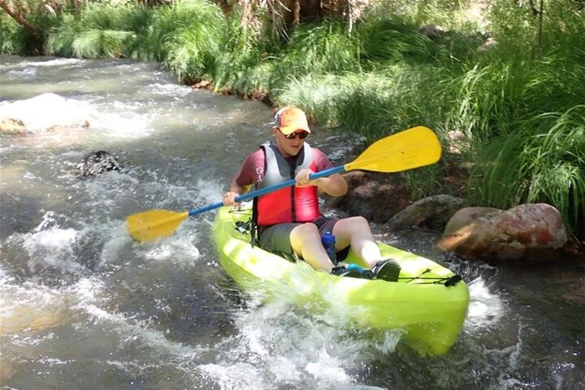 Un hombre está en un kayak en un río.