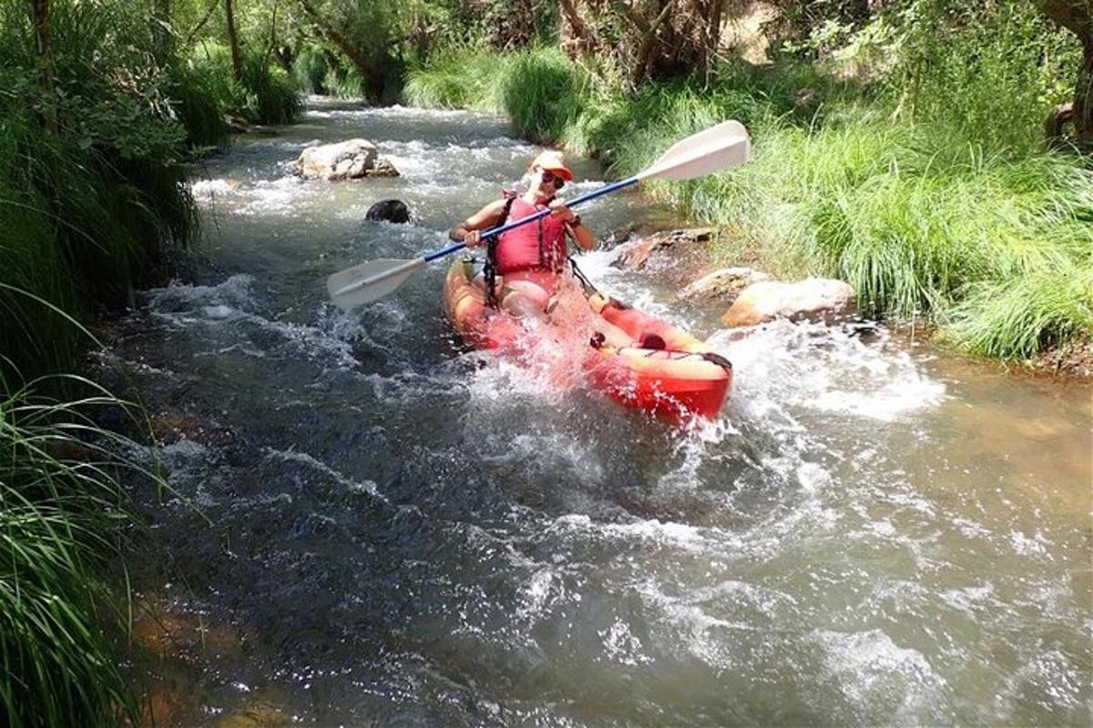 una persona su un kayak rosso in un fiume