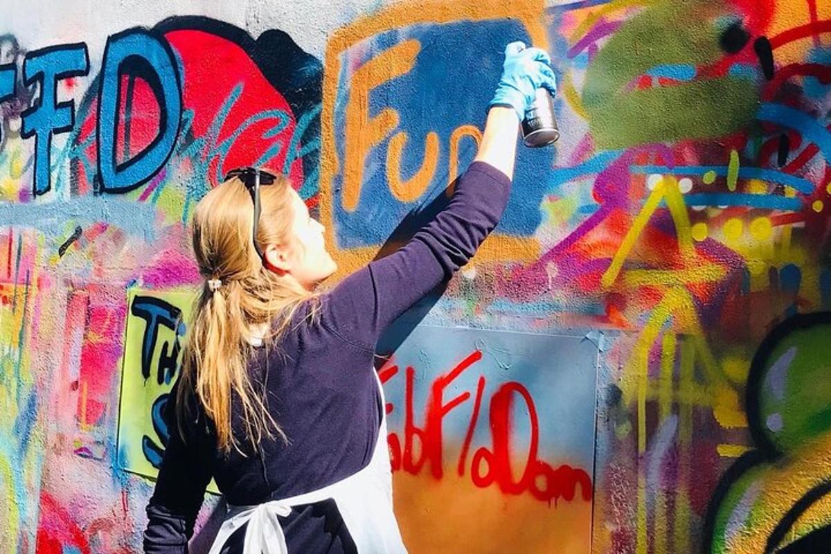 uma mulher está pintando uma parede com grafite