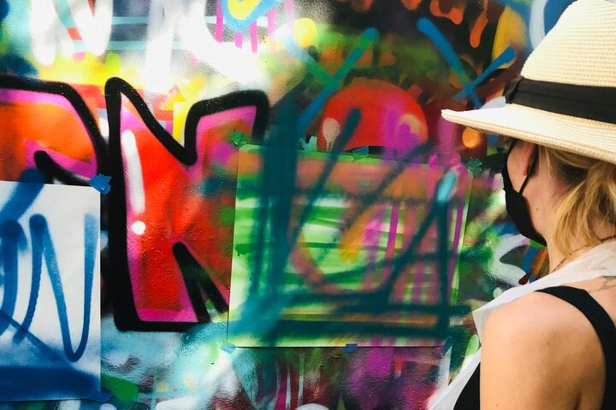 uma mulher usando um chapéu em pé em frente a uma pintura