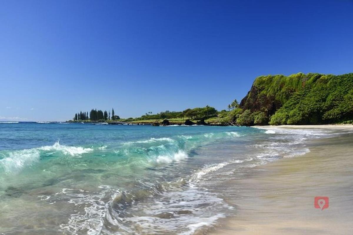 a beach with a wave breaking on the shore