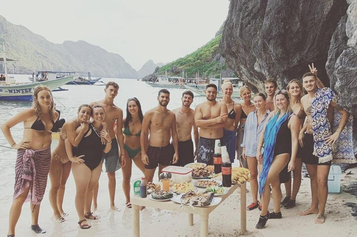 a group of people posing for a picture on the beach