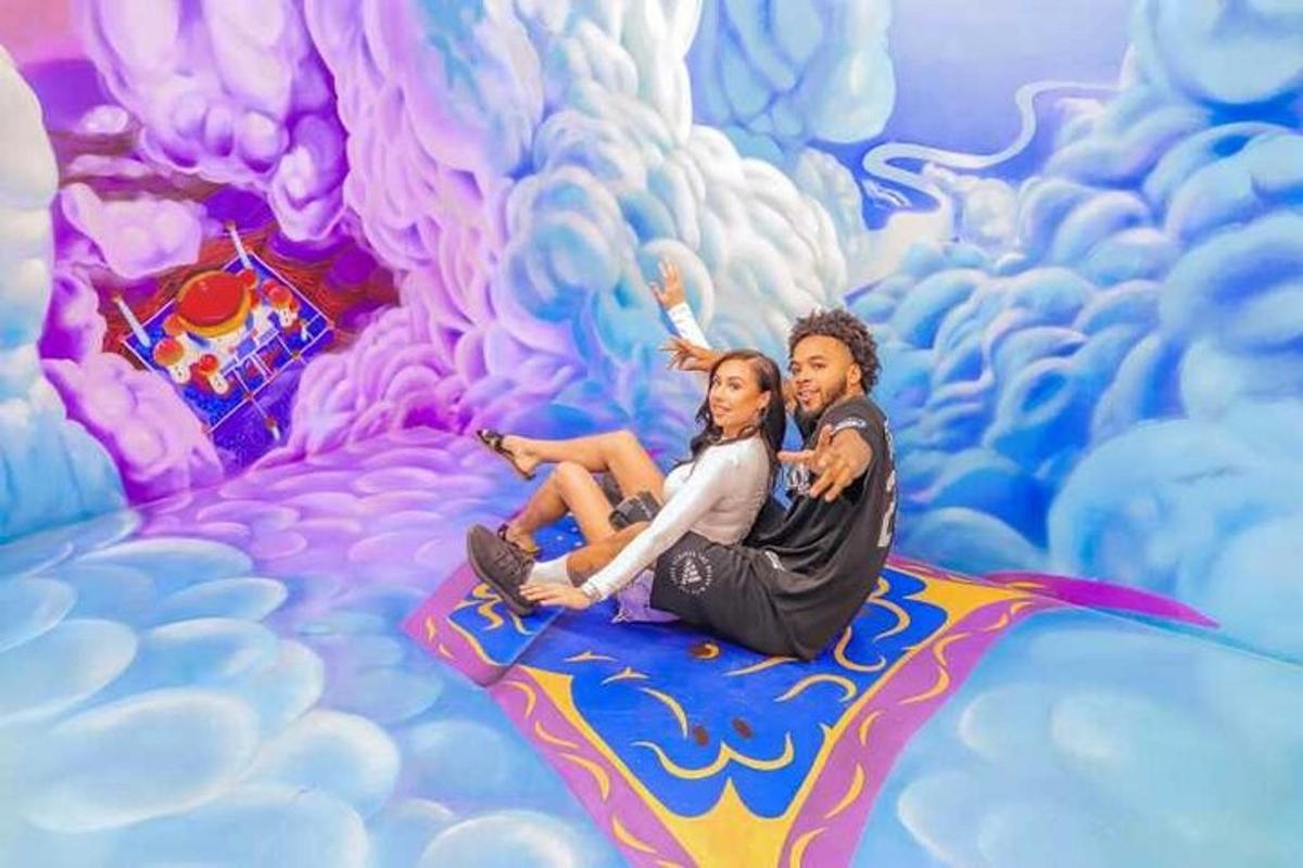 a man and woman sitting on top of a painting