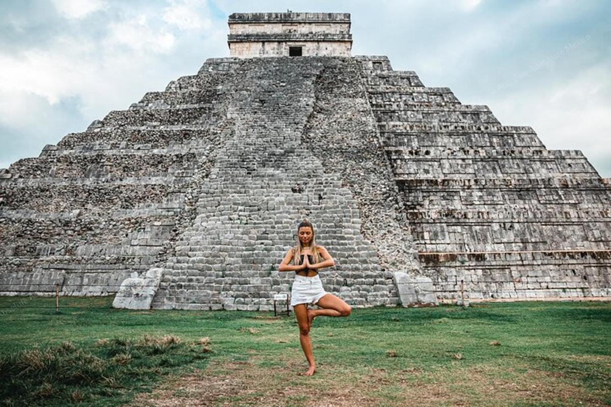 žena cvičící jógu před pyramidou