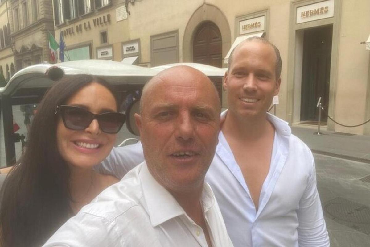 dois homens e uma mulher posando para uma foto