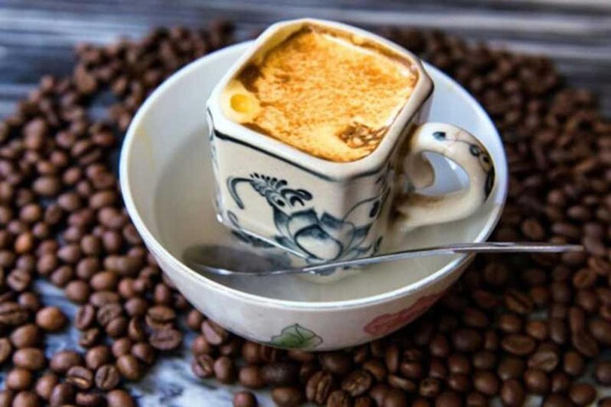 uma xícara de café em um prato com grãos de café