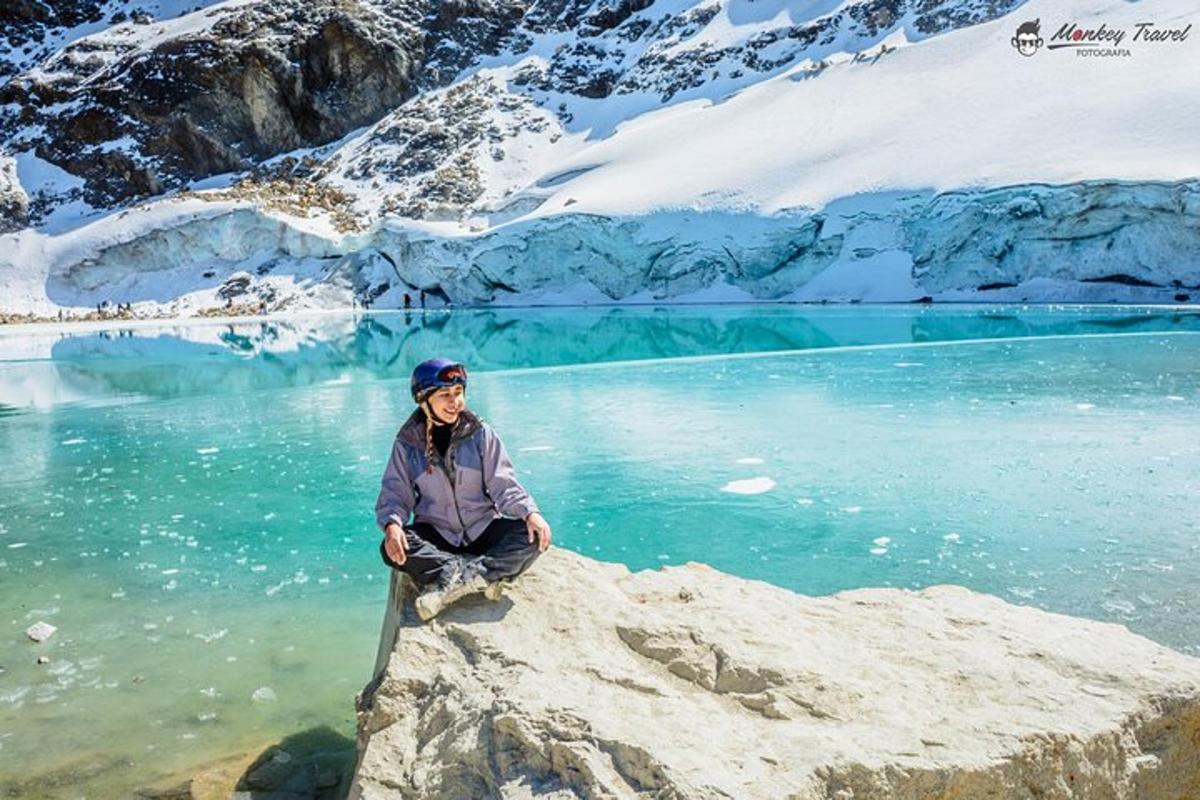 a person sitting on a rock in front of a lake
