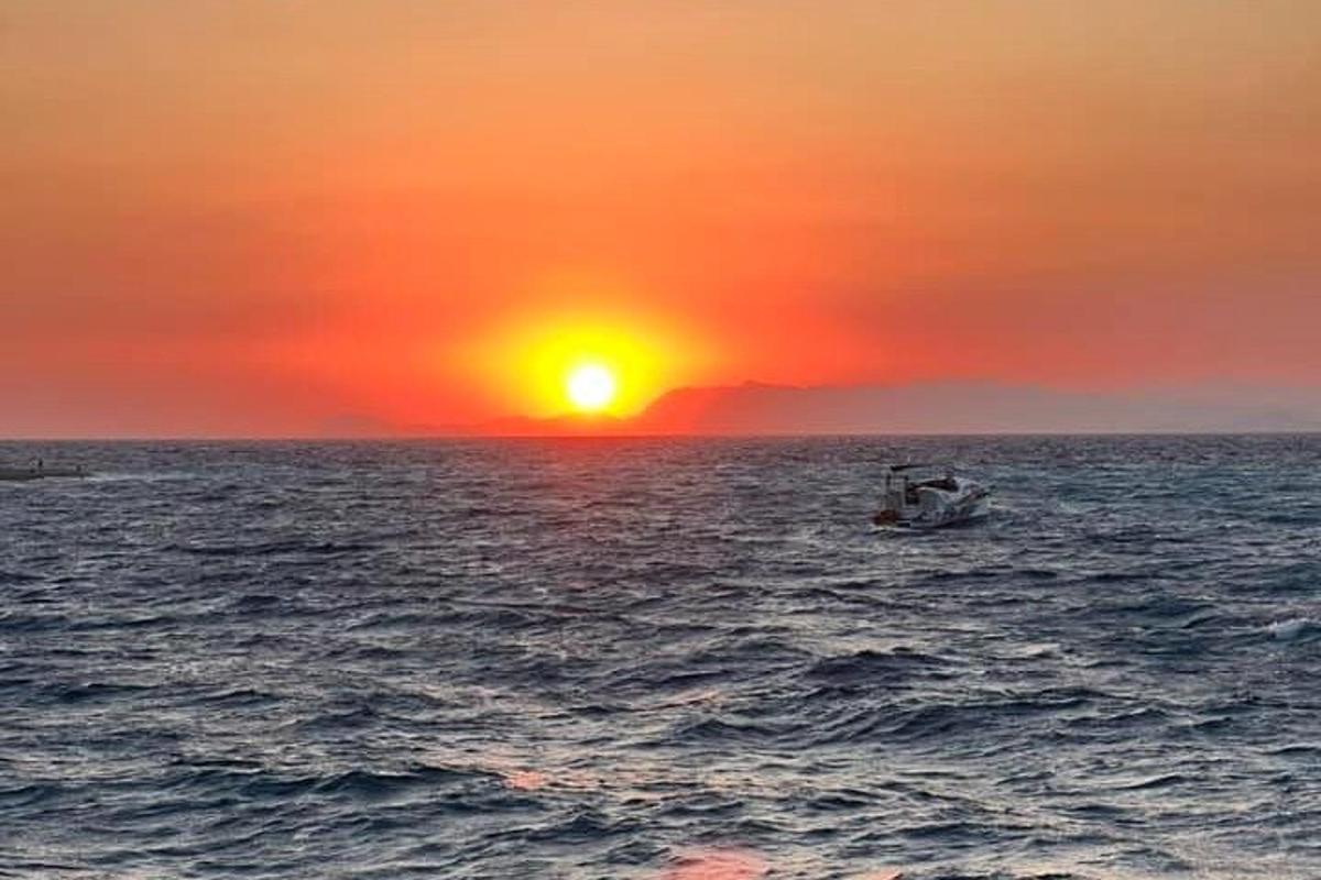 un vaixell a l'oceà amb una posta de sol