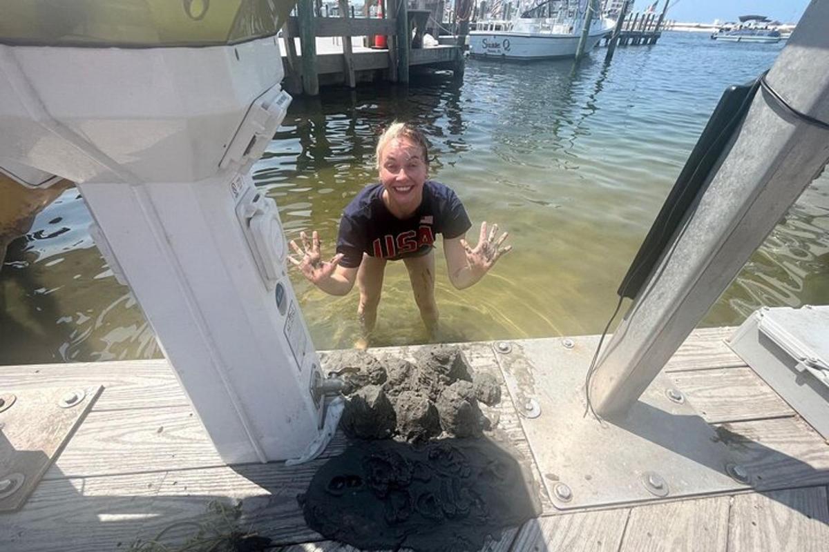 a young boy standing in the water on a dock
