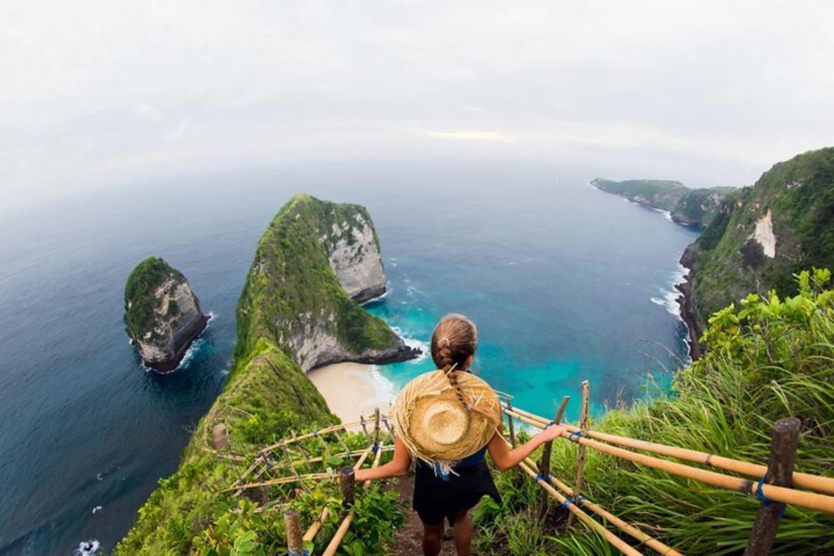 a woman standing on a cliff looking at the ocean