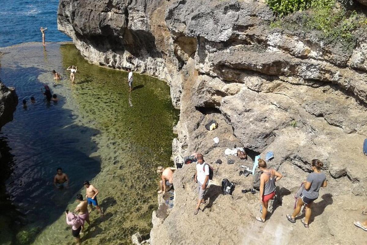a group of people standing in the water at a beach
