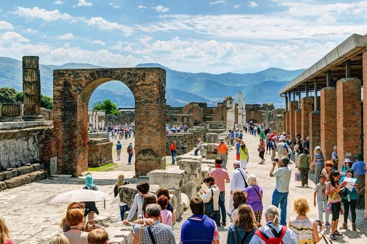 dav lidí procházejících se kolem ruin