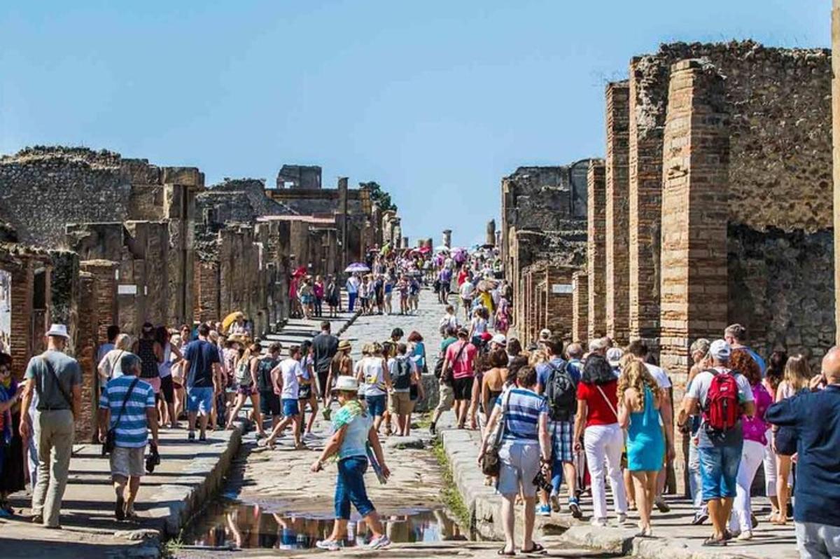 Una gran multitud de personas caminando alrededor de las ruinas.