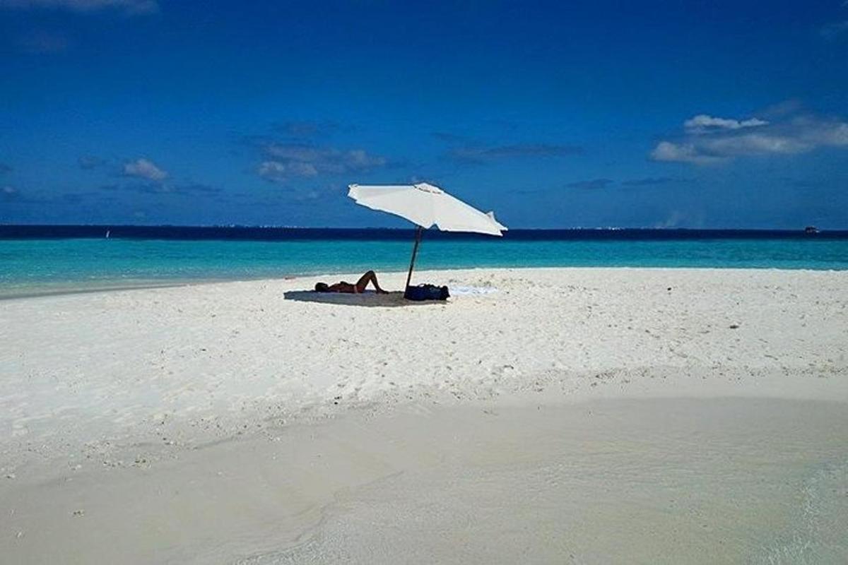 a person laying under an umbrella on a beach