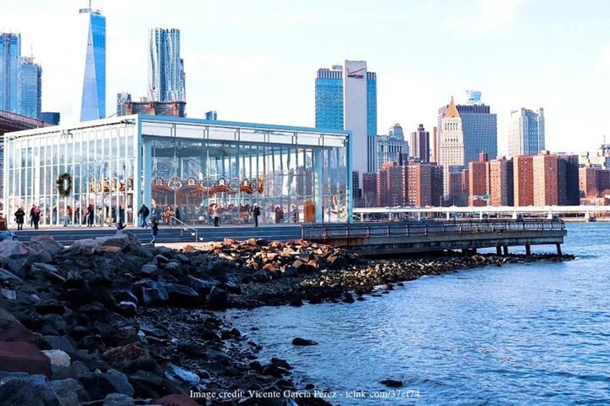 Un gran edificio de cristal en un muelle junto al agua.