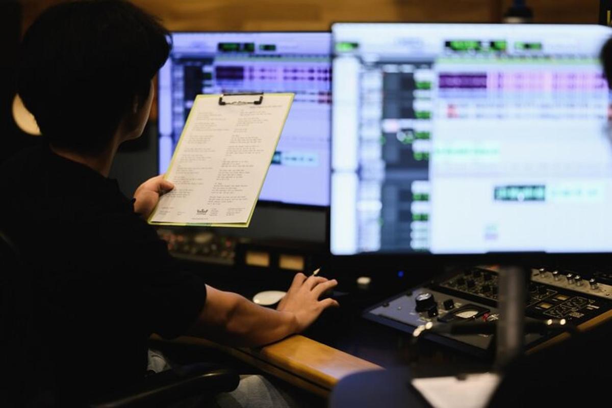egy férfi ül két számítógép-monitor előtt