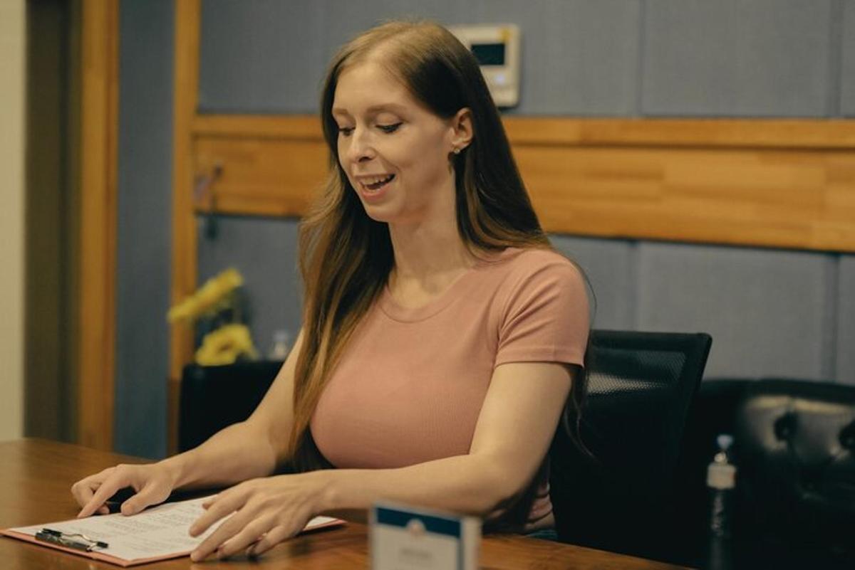 žena sedící u stolu a používající notebook