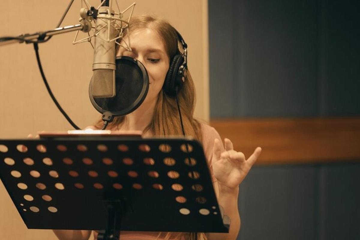 žena se sluchátky, mikrofonem a notebookem