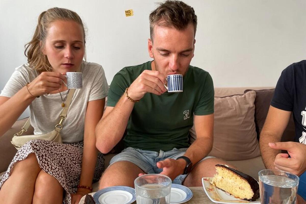 un bărbat și o femeie stând pe o canapea, bând cafea