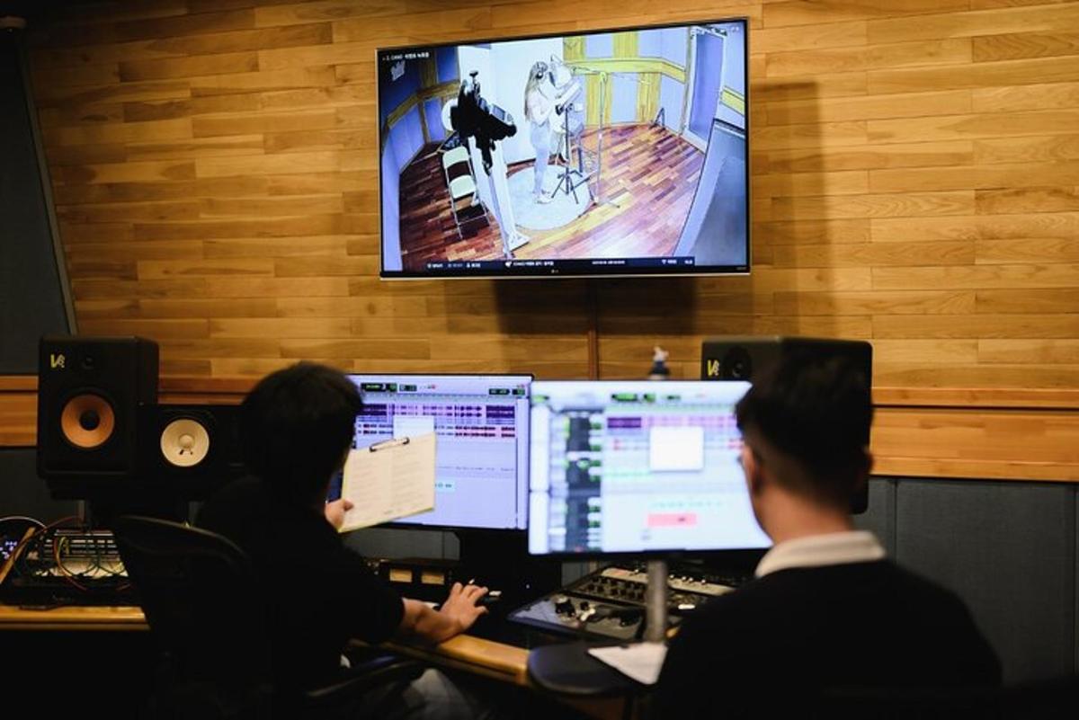 due persone sedute a una scrivania con due monitor di computer