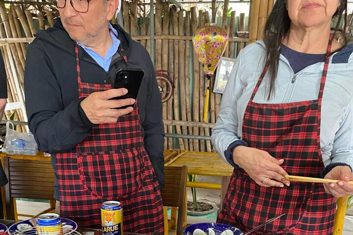 seorang lelaki dan seorang wanita dalam apron melihat telefon bimbit