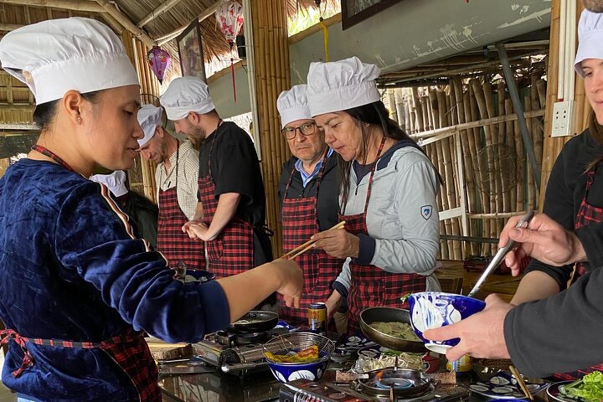 un gruppo di chef in piedi in una cucina che prepara il cibo