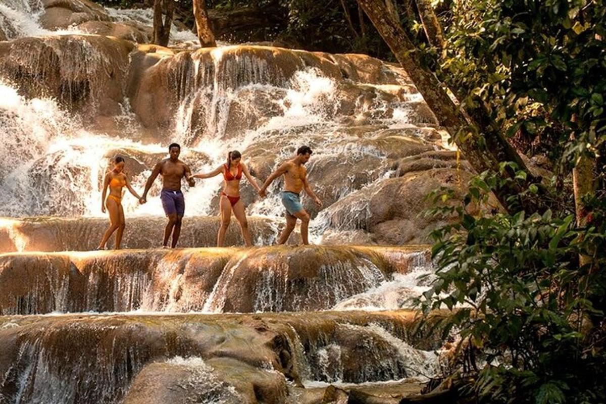 vier mensen staan op rotsen in een waterval