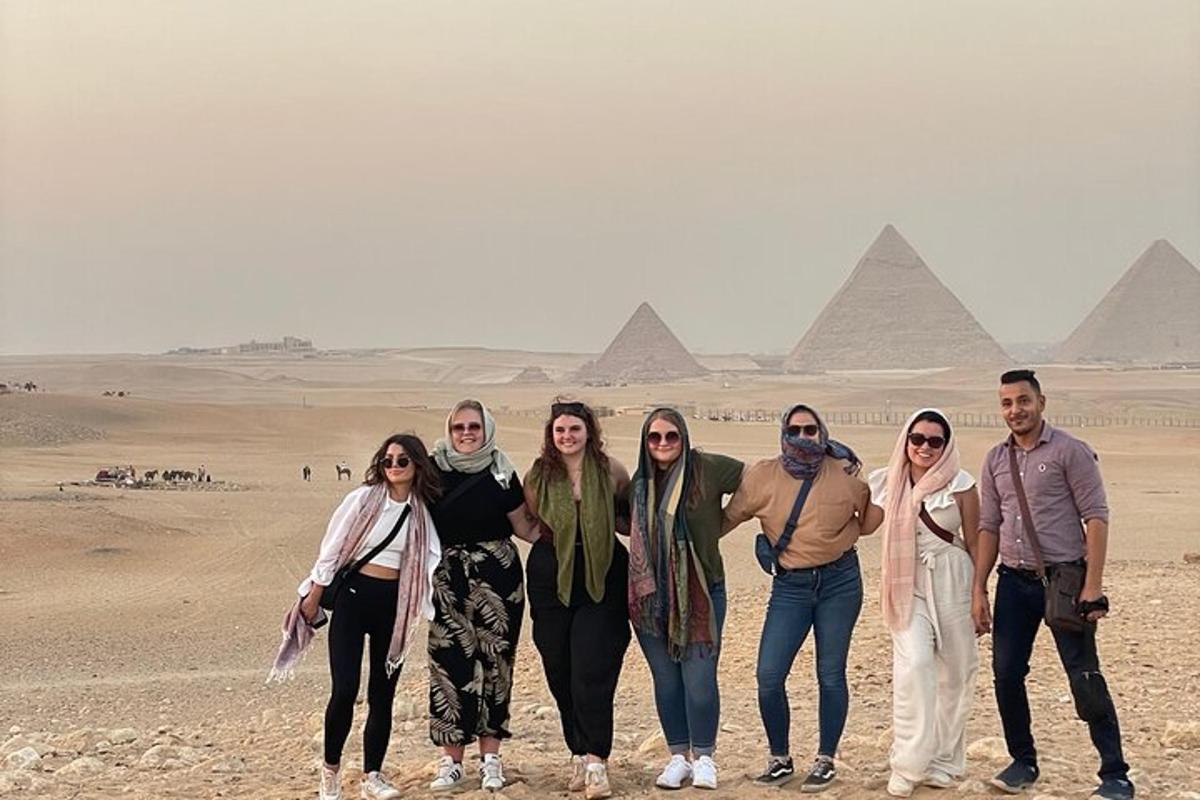 skupina lidí stojící před pyramidami