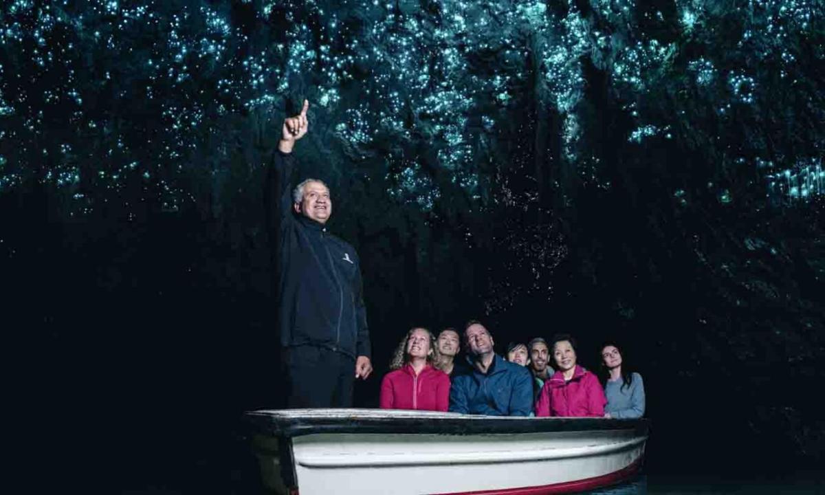 a man standing in a boat with a group of people