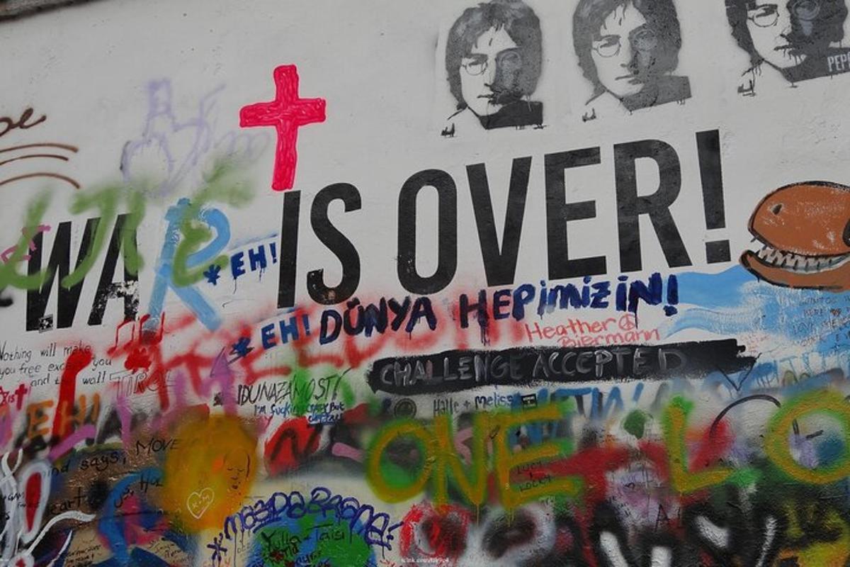 zeď pokrytá graffiti s křížem
