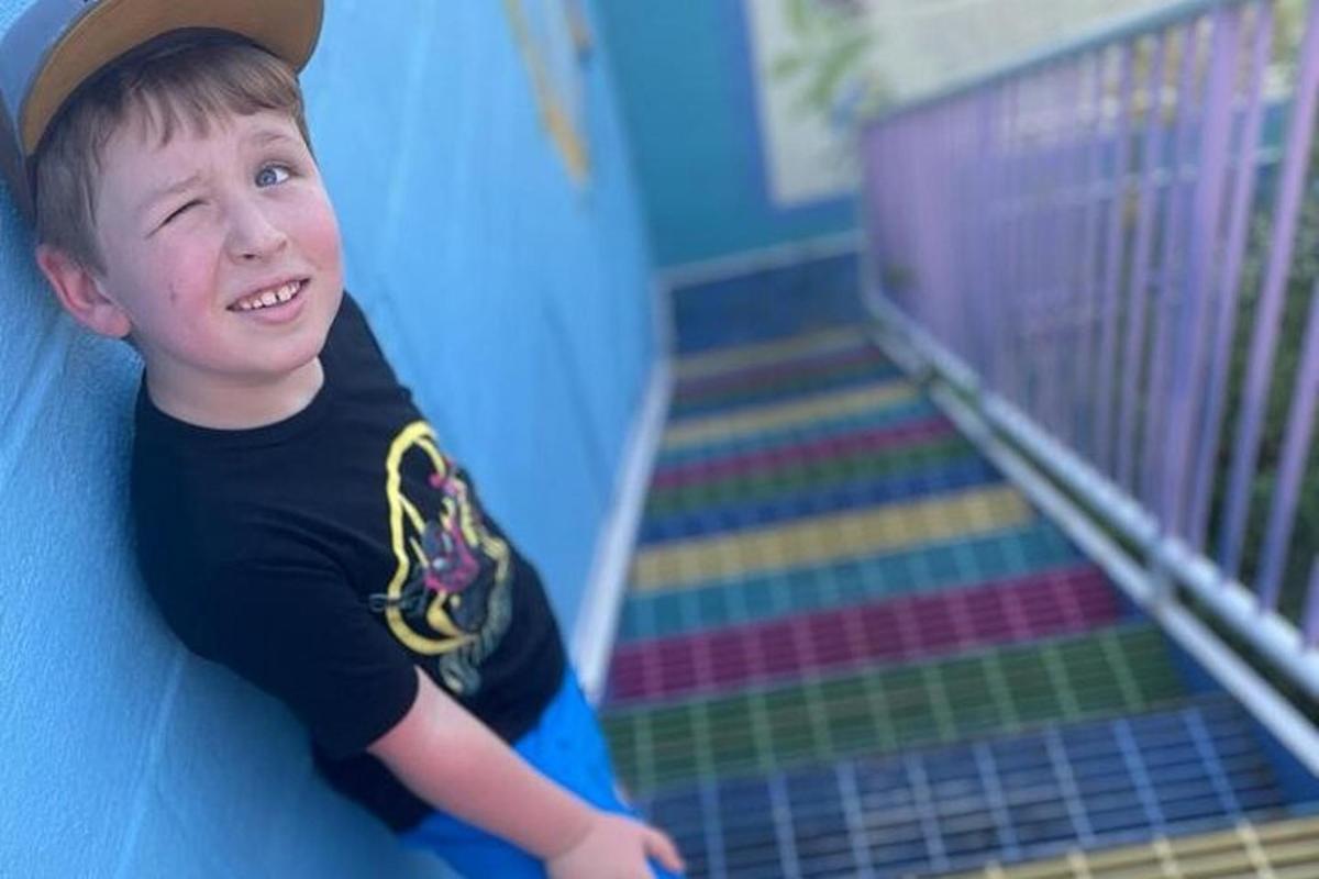 a young boy is sliding down a slide