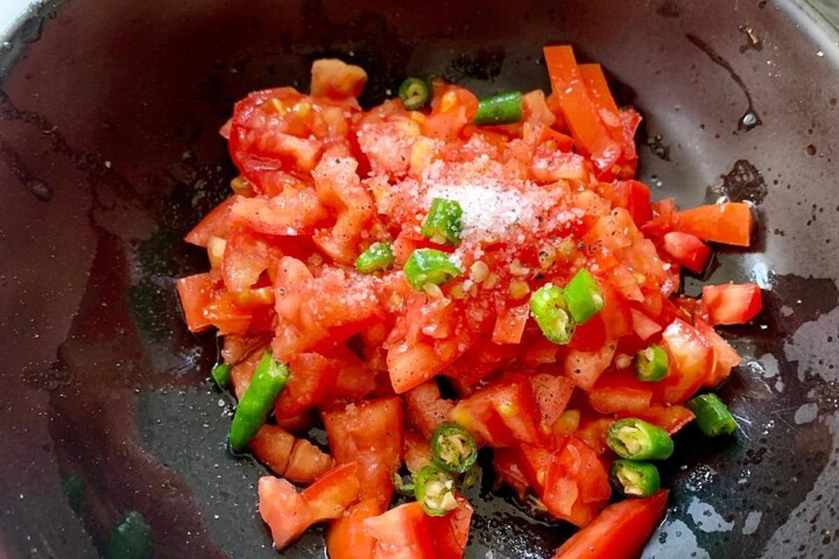 uma tigela de comida com tomates e cebolinhas