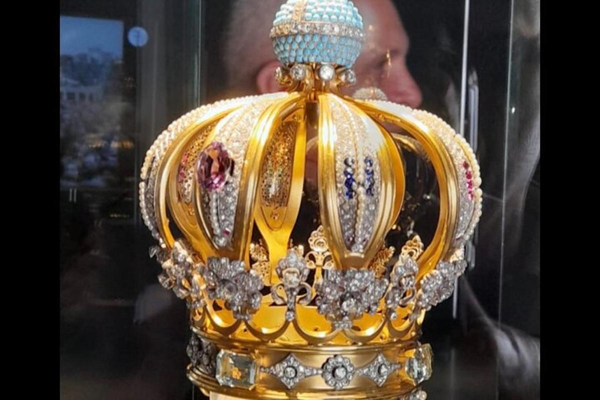 en gullkrone med diamanter og en blå perle