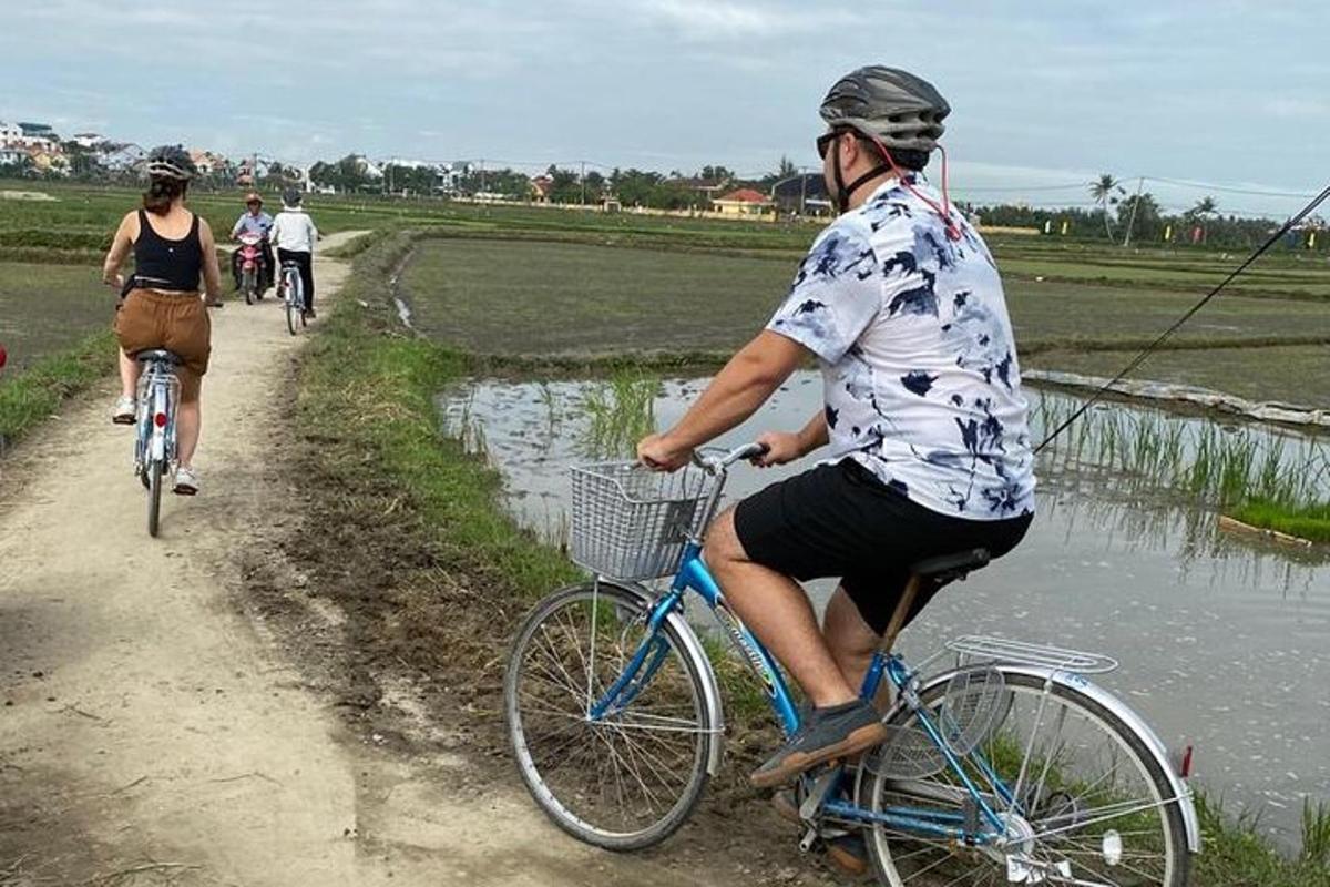 một người đàn ông đang đạp xe trên một con đường đất