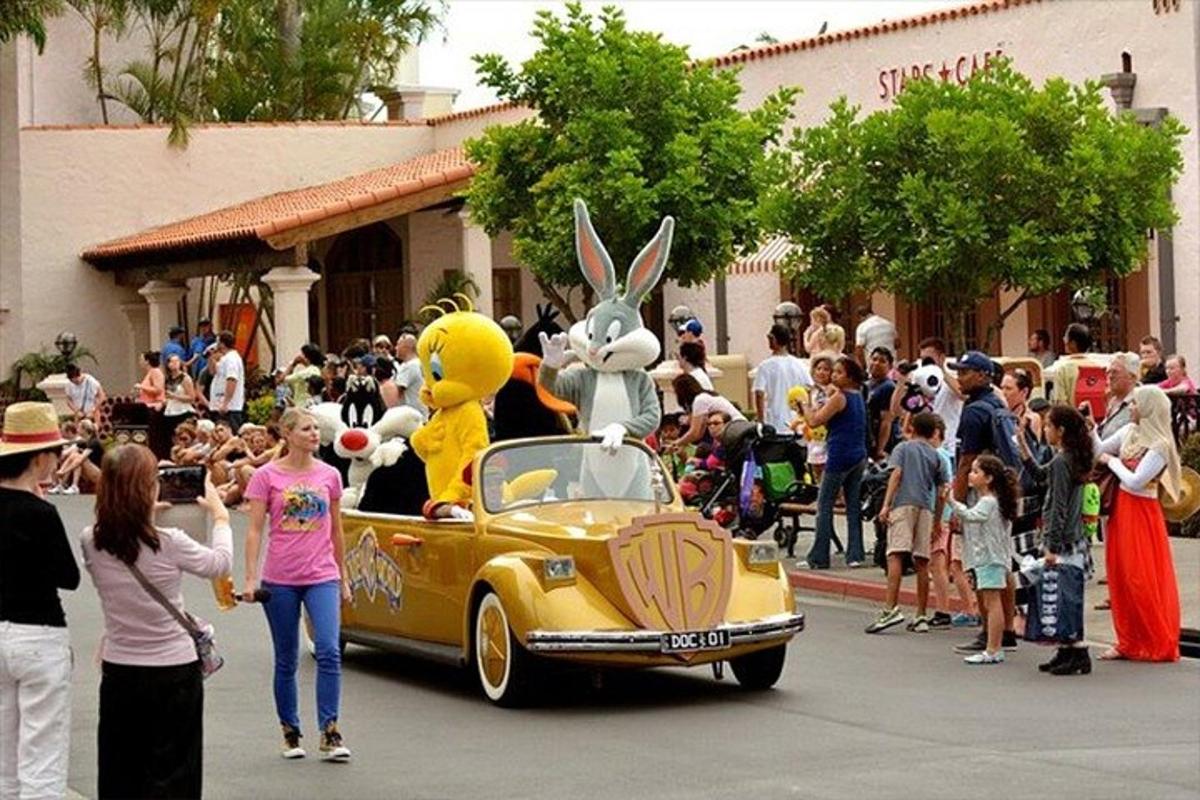 a group of people standing around a yellow car in a parade