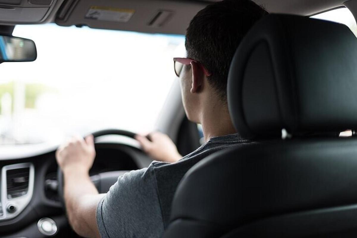 un homme conduisant une voiture tout en portant des lunettes