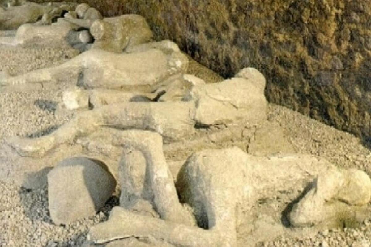 uma estátua de um ursinho de pelúcia deitado em algumas pedras