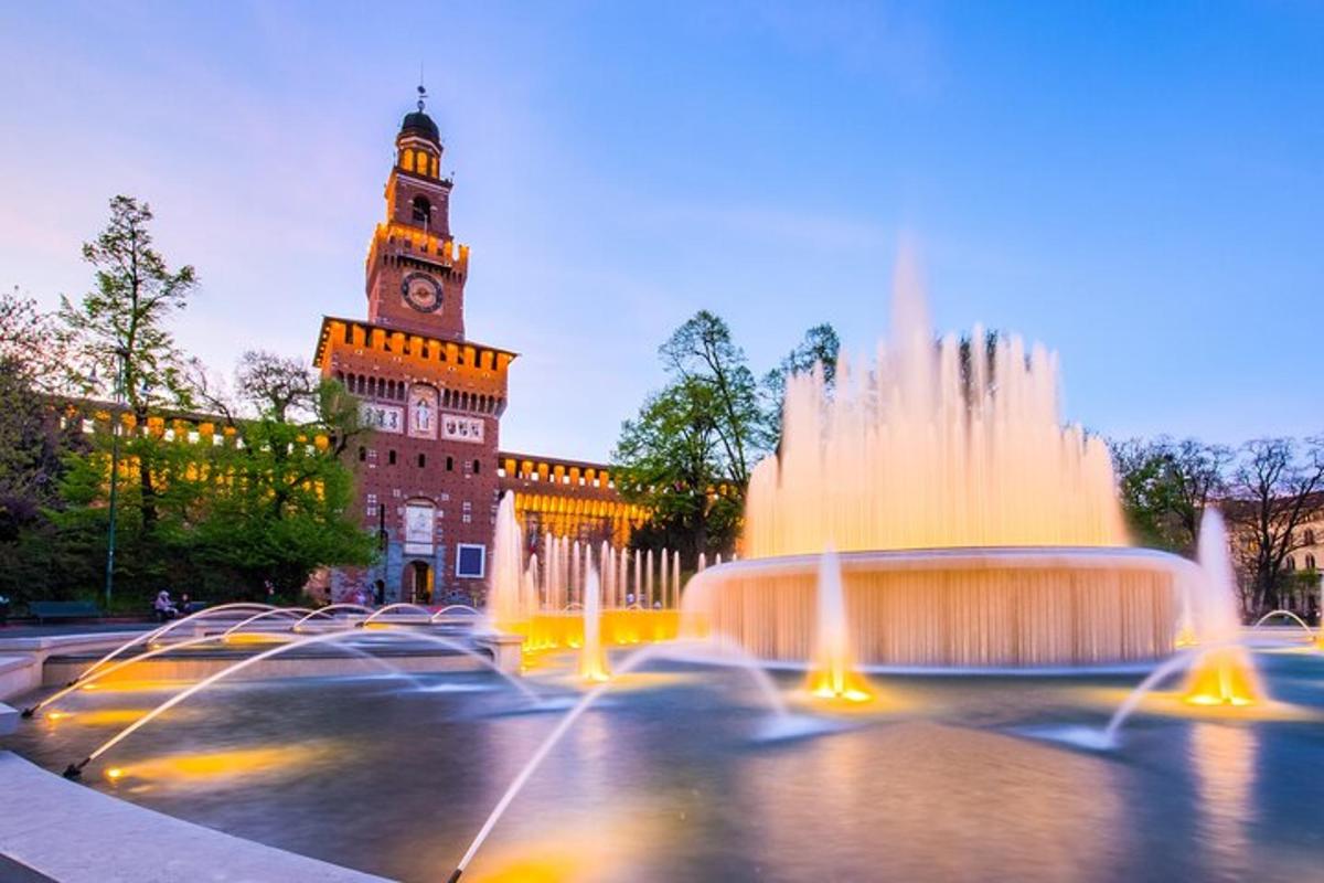 una fontana d'acqua di fronte a un edificio con una torre dell'orologio