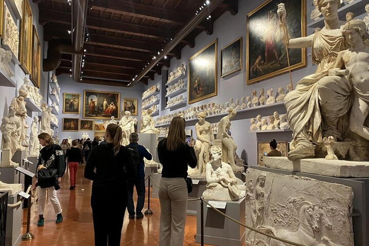 a group of people walking through a museum with statues