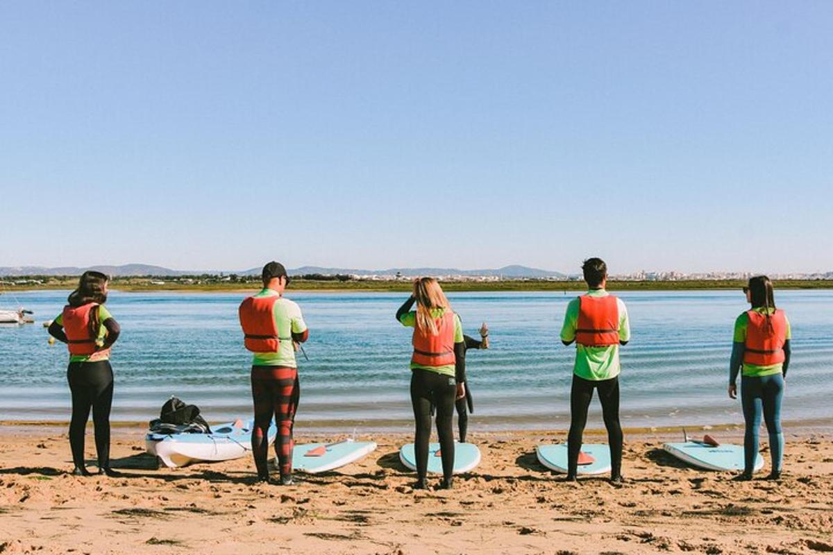 un gruppo di persone in piedi su una spiaggia con tavole da surf