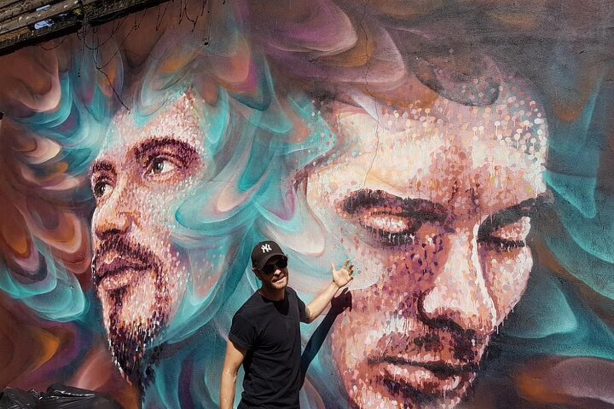 un home dret davant d'una paret amb un mural