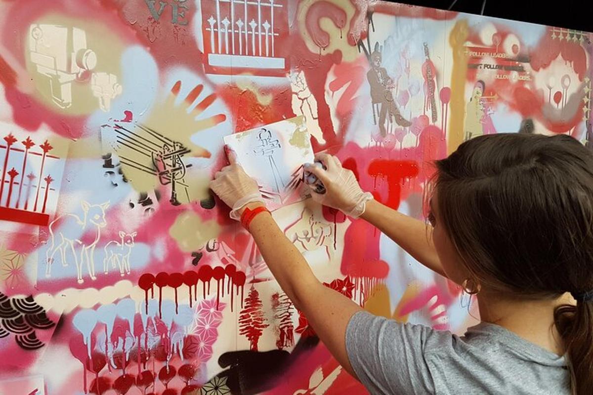 eine Frau bemalt eine Wand mit Graffiti